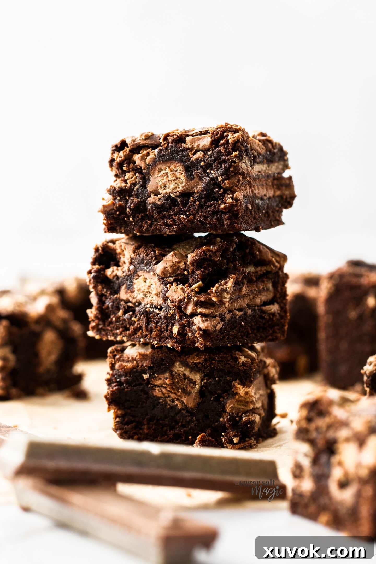 A perfectly stacked trio of fudgy Kit Kat brownies, showing off their thick layers and tempting interior.