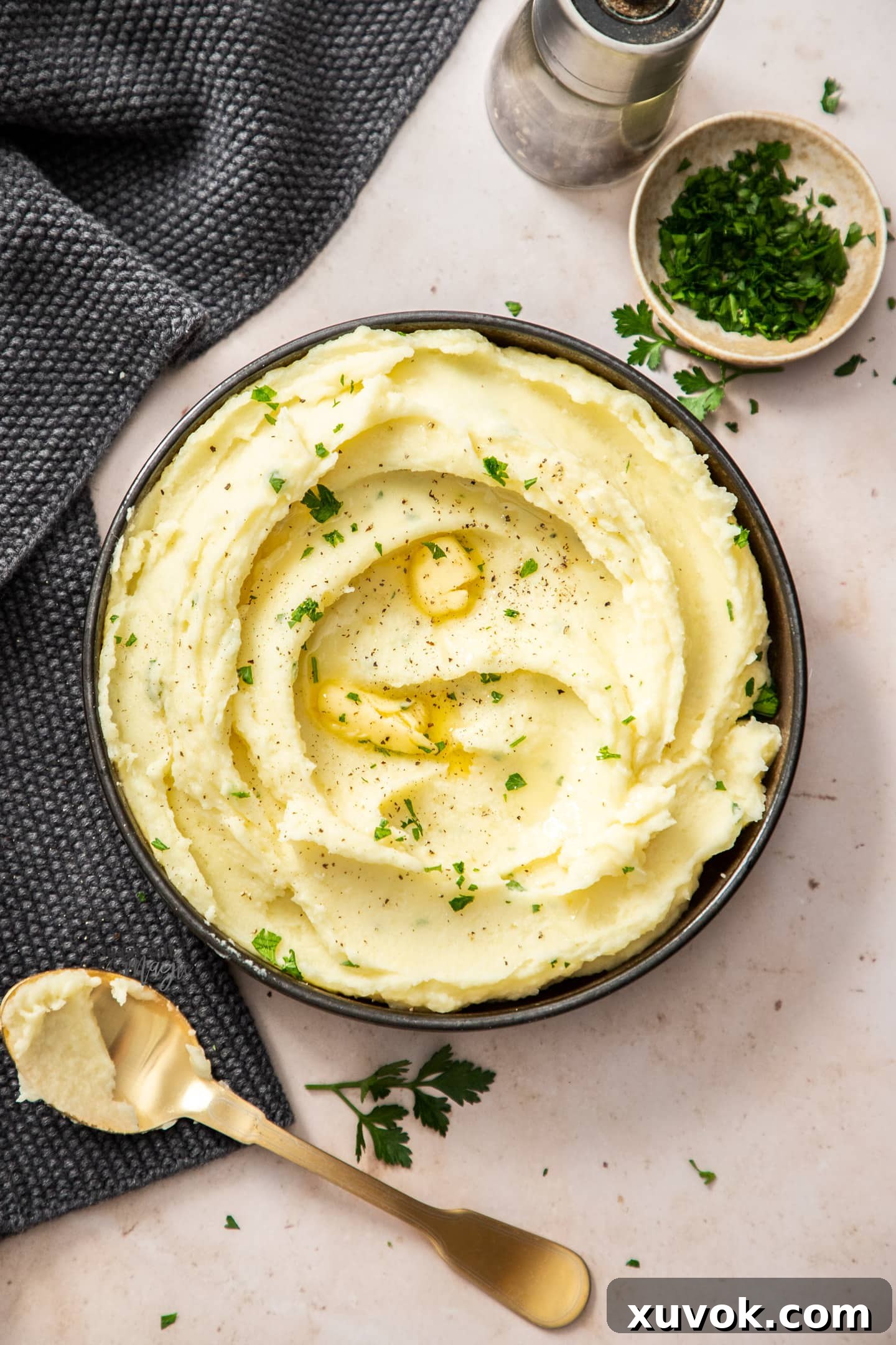Top down view of mashed potato in a dark bowl.