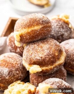 A pile of Bavarian donuts in a wooden tray.