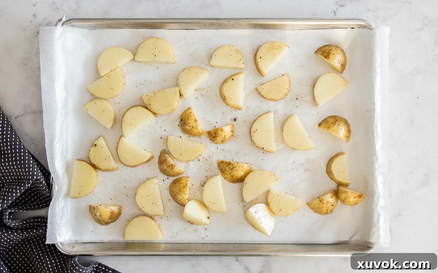 Potatoes on a tray ready to be baked.