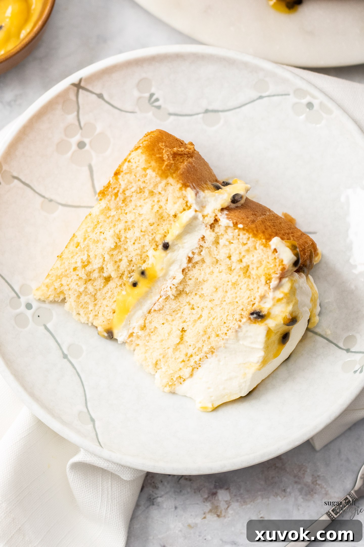 A slice of passionfruit sponge on a small dessert plate, ready to be enjoyed.
