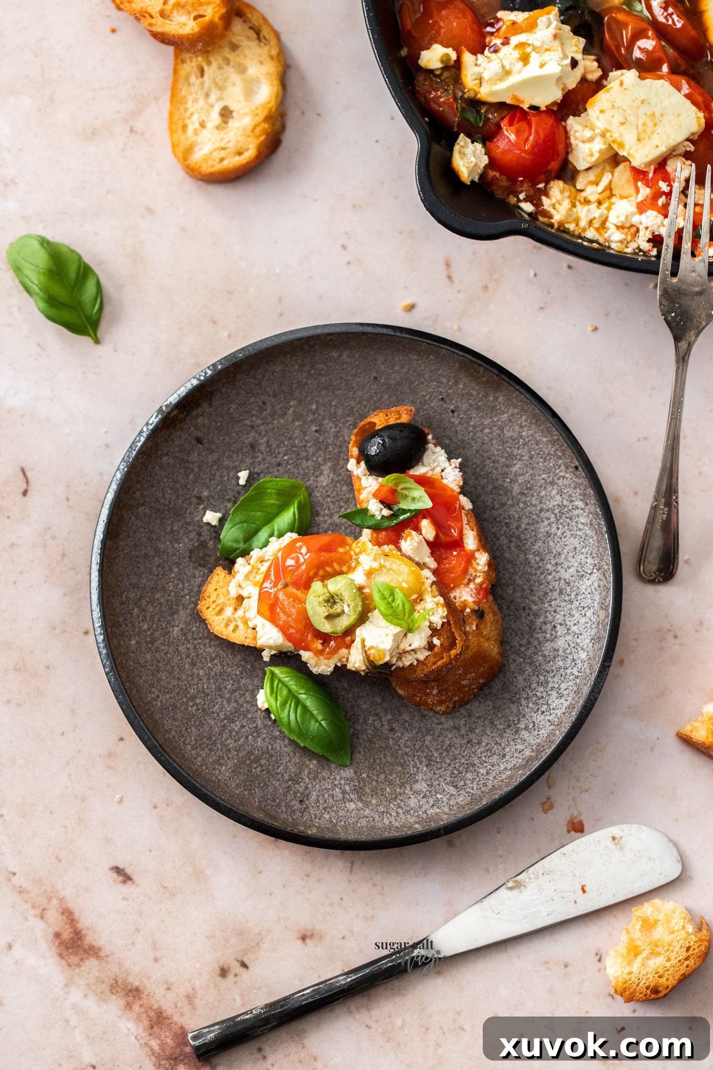 Tomatoes and feta generously spread on crispy crostini, ready to be enjoyed as an appetizer.