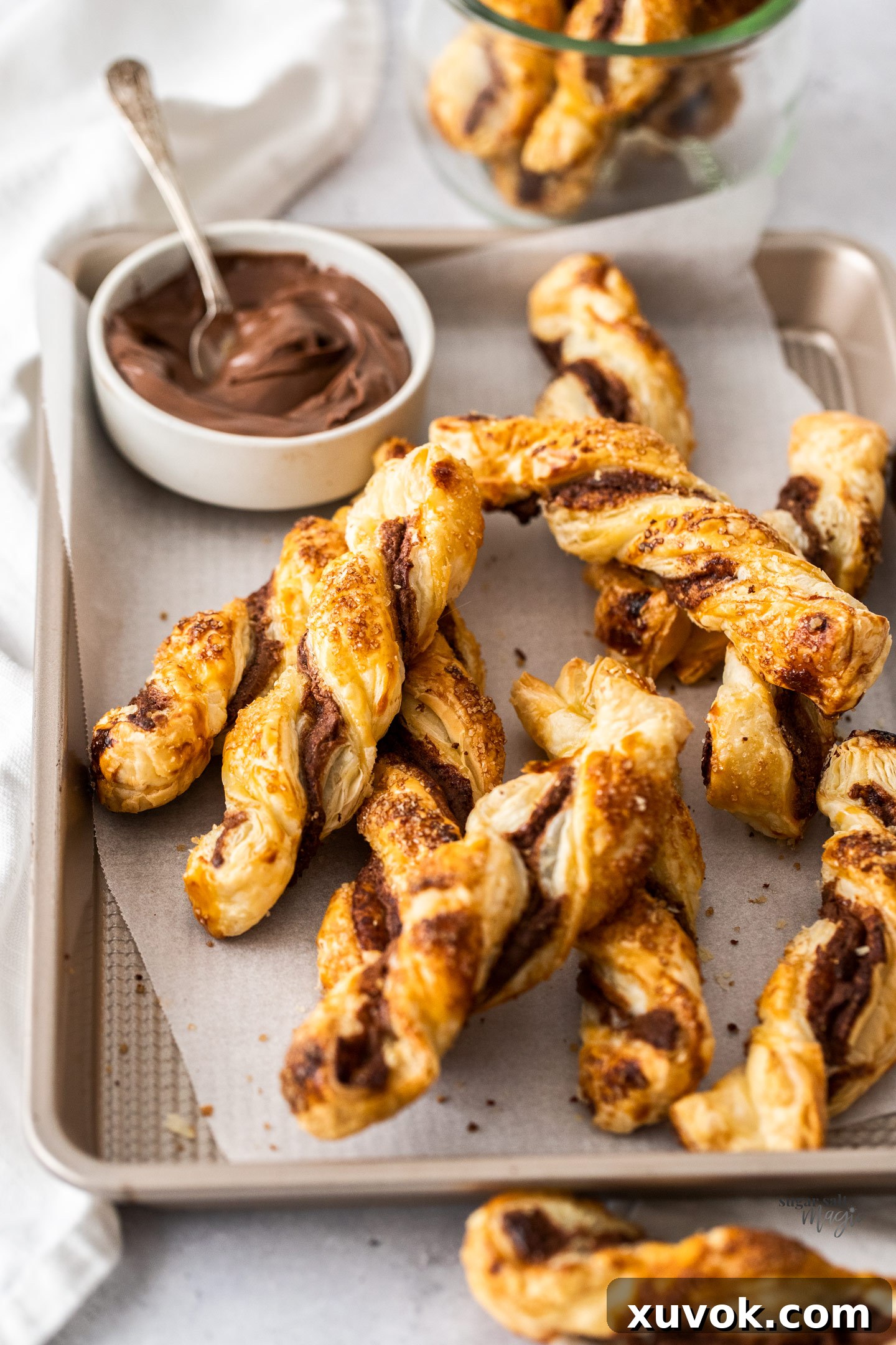 A batch of Nutella twists on a rose gold baking tray, showcasing their golden-brown finish.