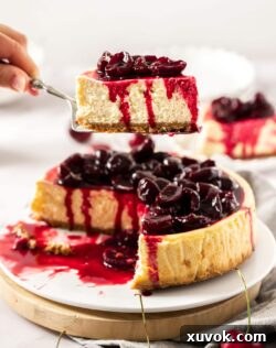 A slice of cherry cheesecake being held on a cake slice