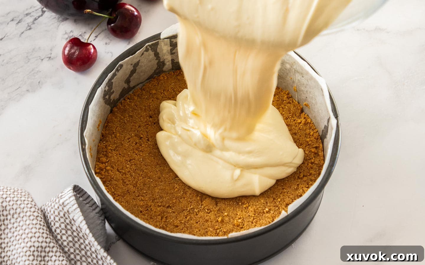 Pouring the cheesecake batter into the pan.