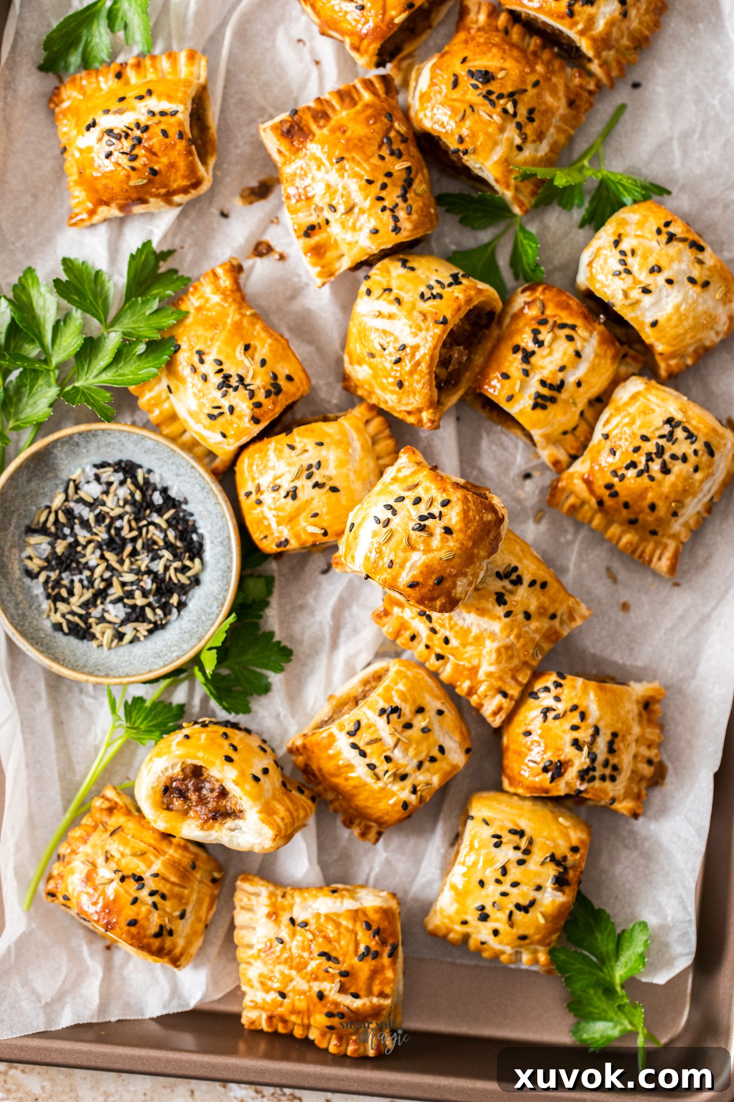 A baking tray filled with mini Italian sausage rolls, golden brown and flaky.