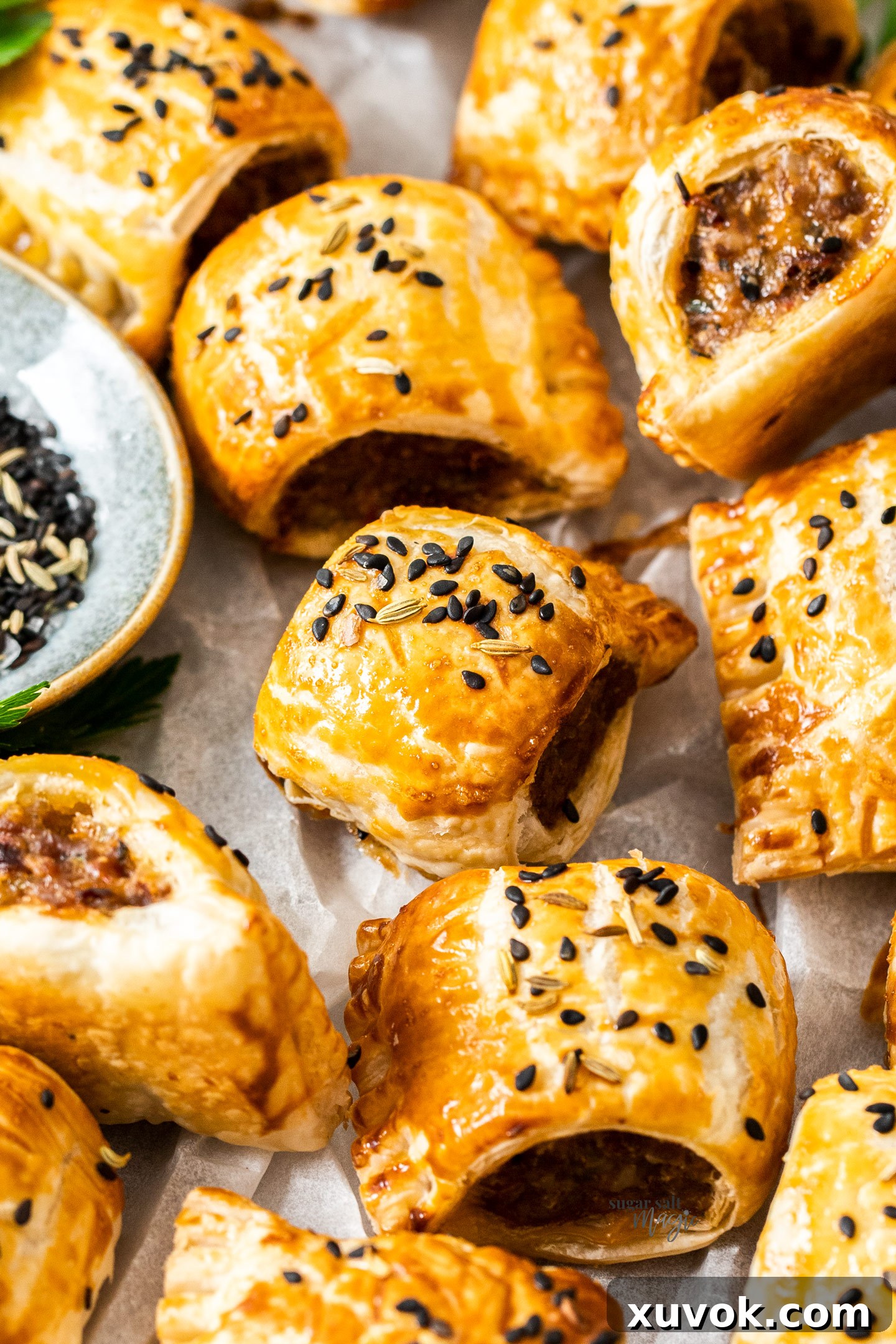 A close-up shot of the golden-brown, flaky top of an Italian sausage roll, fresh from the oven.