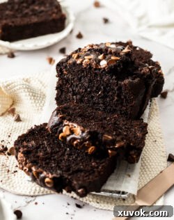A freshly baked chocolate zucchini cake, perfectly sliced and cooling on a wire rack.