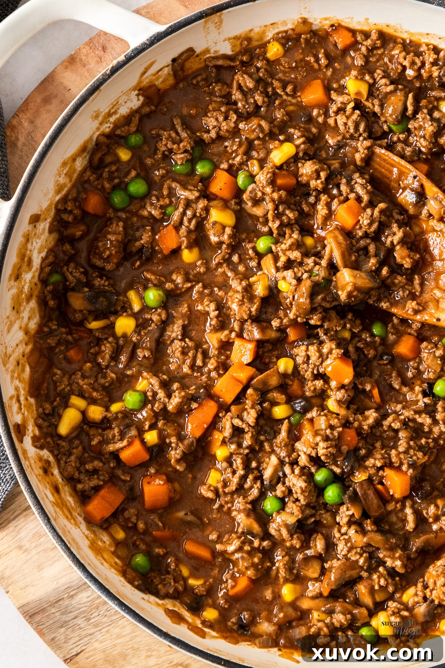 A close-up shot of rich savoury mince bubbling in an enamel pan.