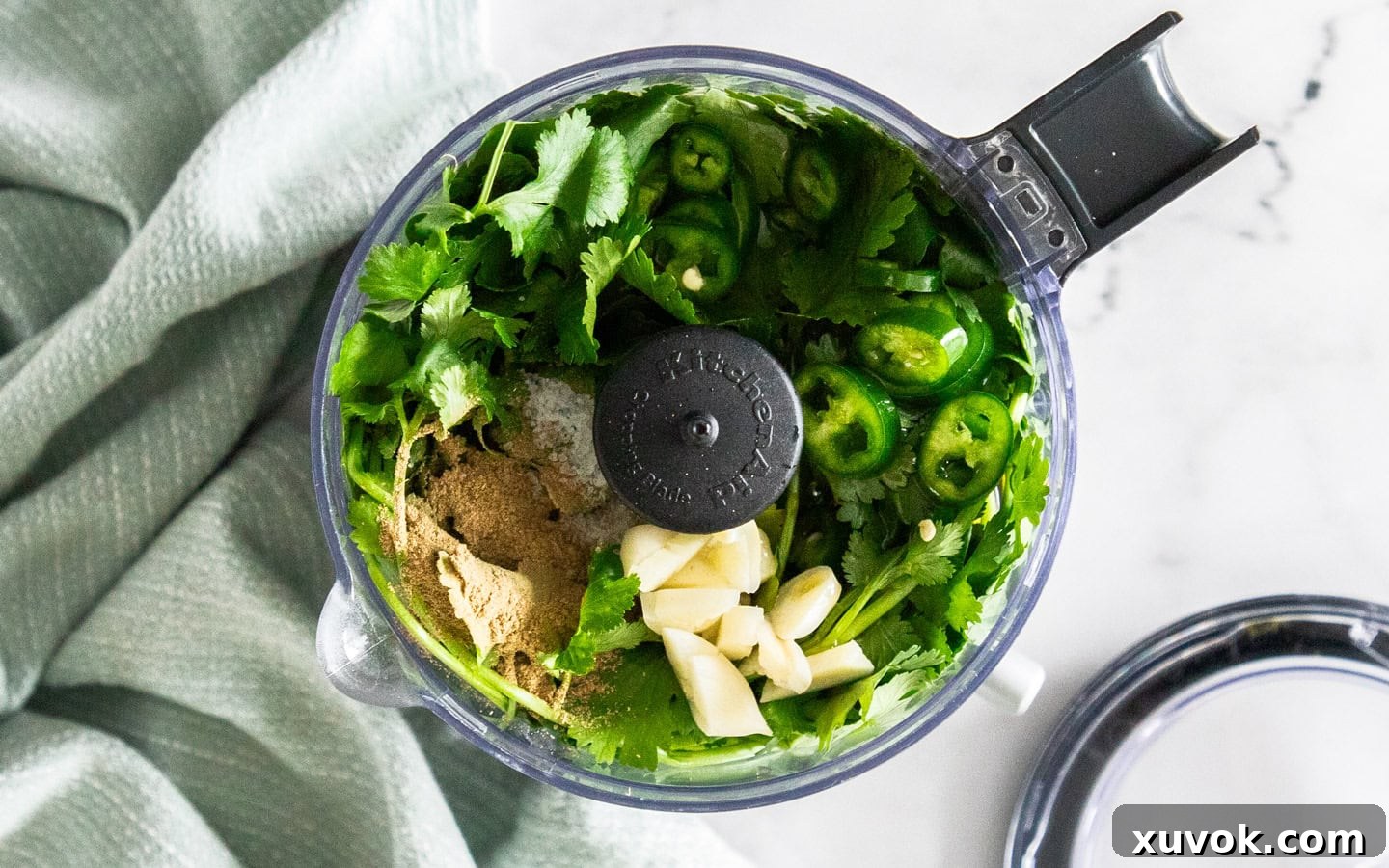 All the mojo verde ingredients placed inside a mini food chopper, ready for blending.