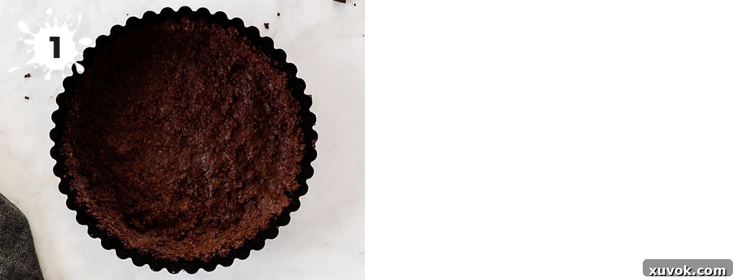 A perfectly formed chocolate cookie crust pressed firmly into a pie tin, ready for filling.