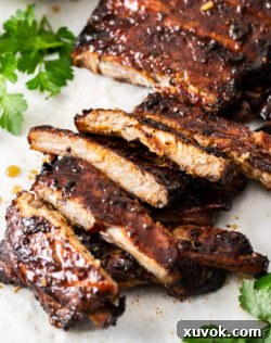 Closeup of perfectly glazed and caramelized honey garlic pork ribs on a baking tray.