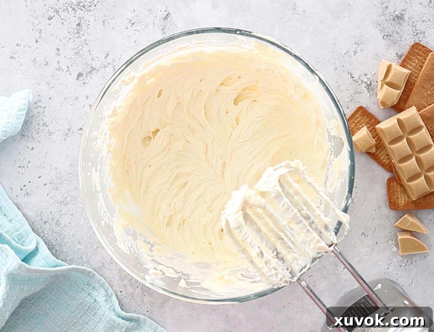 Cream cheese and sour cream mixture smoothly beaten together in a mixing bowl, ready for the next step of the Caramilk cheesecake filling.