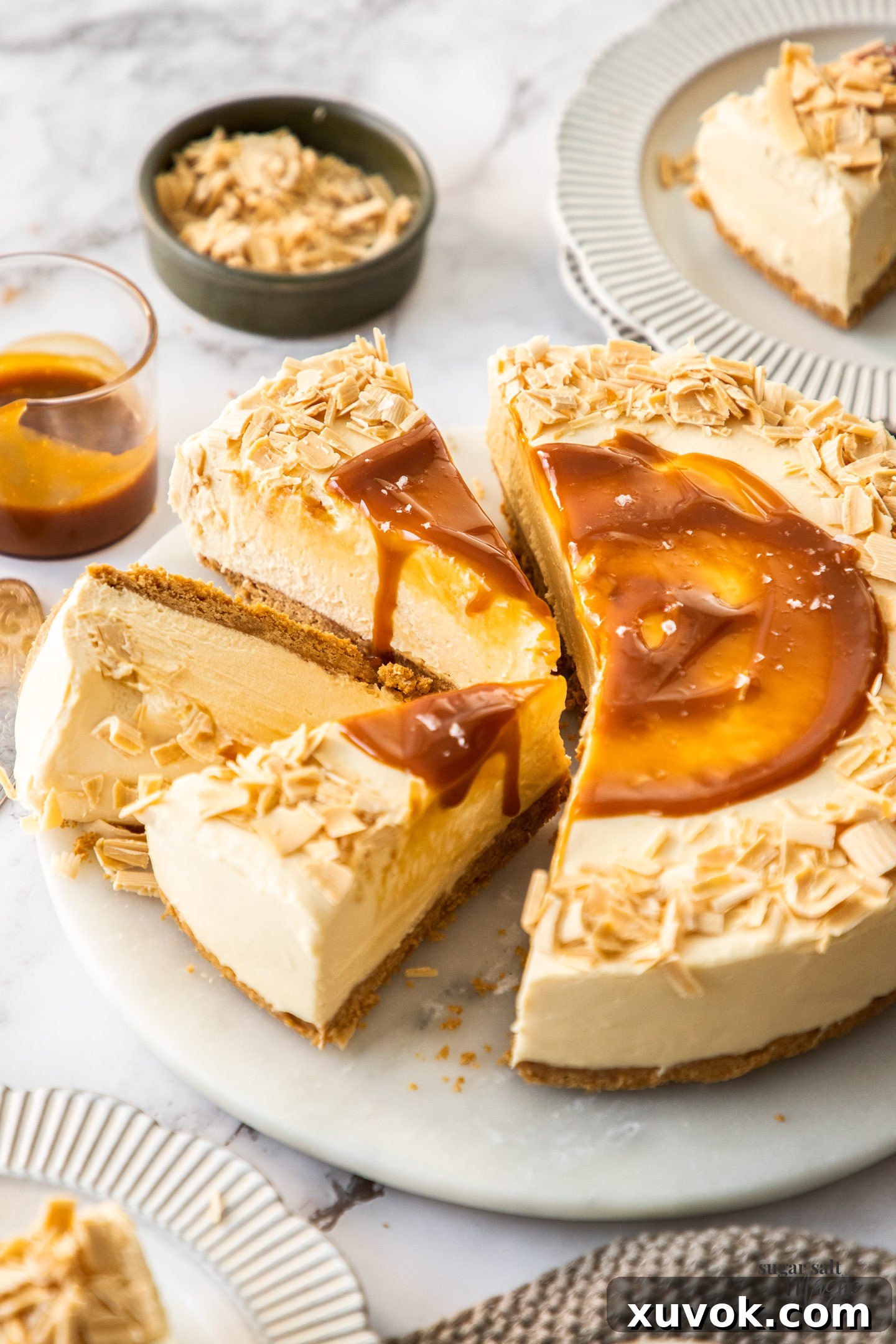 Three perfectly cut slices of rich Caramilk cheesecake arranged next to the remaining whole cheesecake, ready for serving.