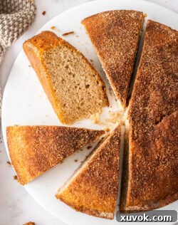 Four golden-brown slices of cinnamon teacake arranged on a decorative cake plate, ready for serving.