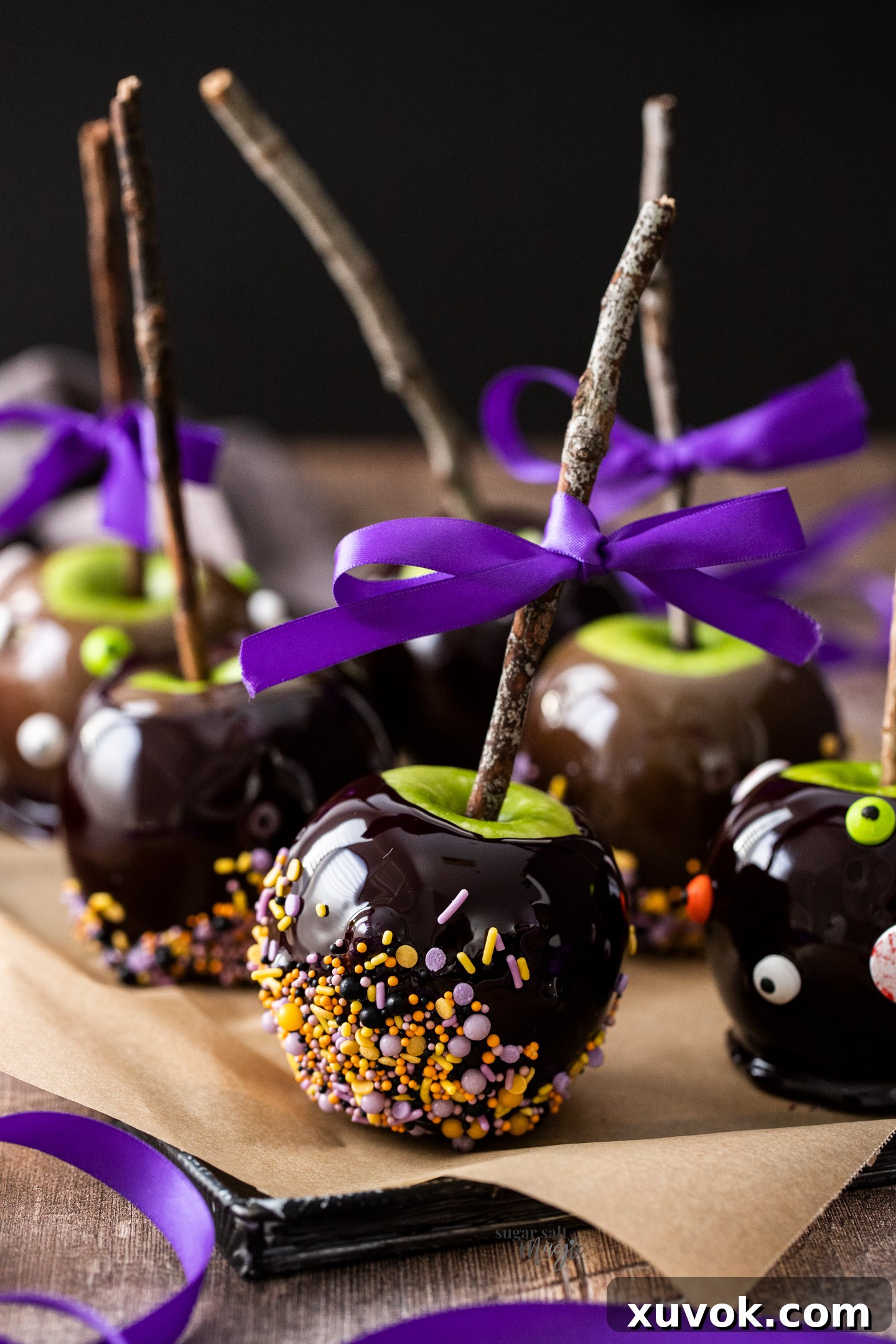 Candy apples on a tray with twigs stuck into the top.