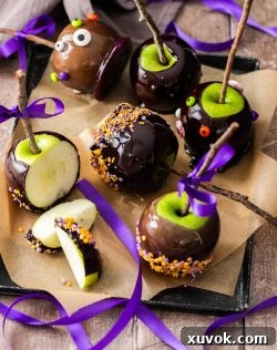 A batch of halloween apples on a metal tray.