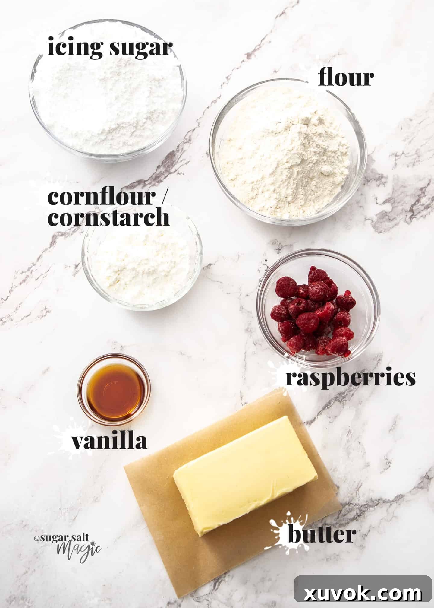 Fresh and high-quality ingredients for making Raspberry Melting Moments cookies, including butter, flour, cornflour, icing sugar, vanilla extract, and raspberries, neatly arranged on a pristine marble countertop.