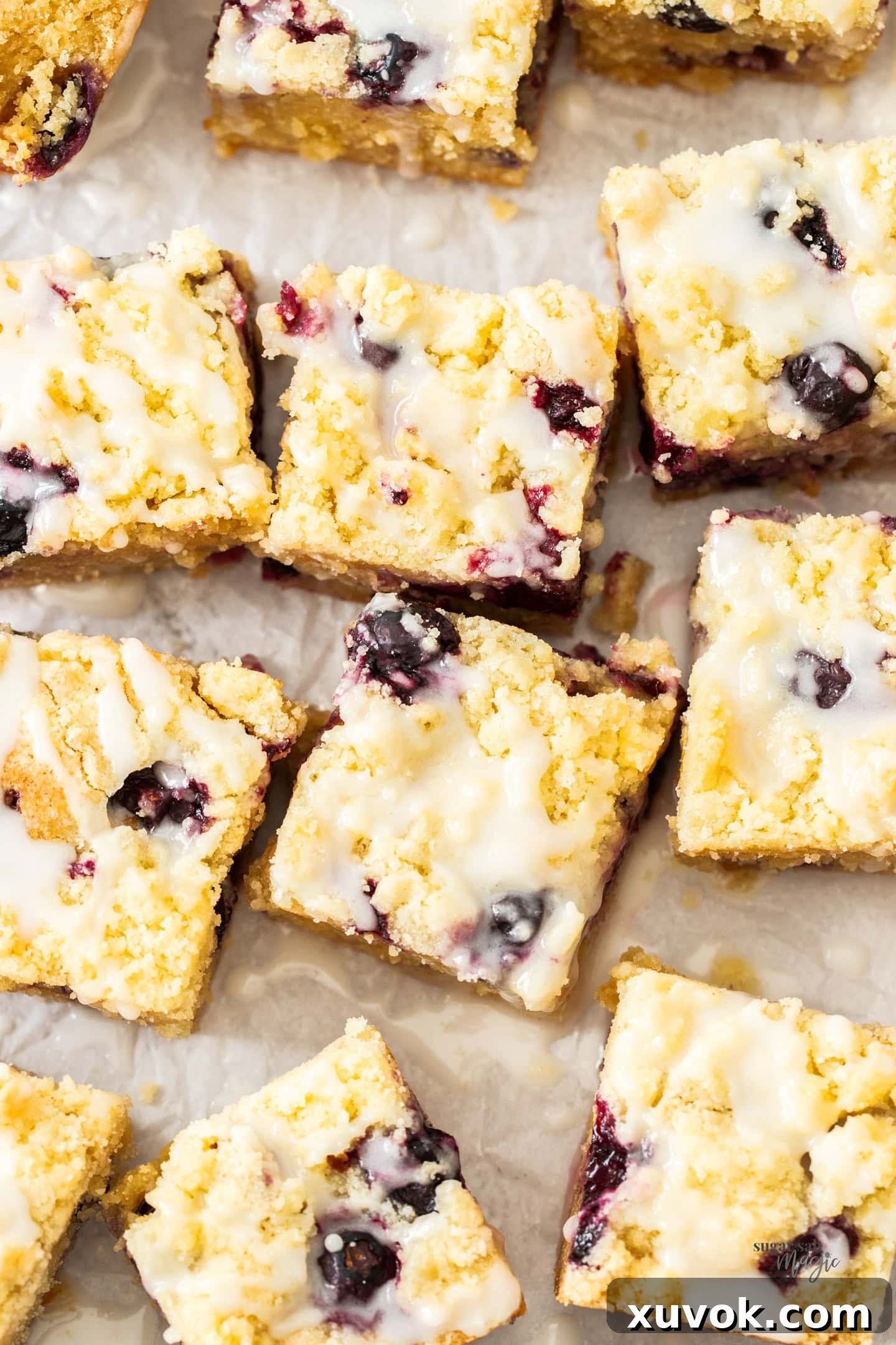 Top down view of 12 chewy blueberry blondies with lemon glaze, neatly arranged.