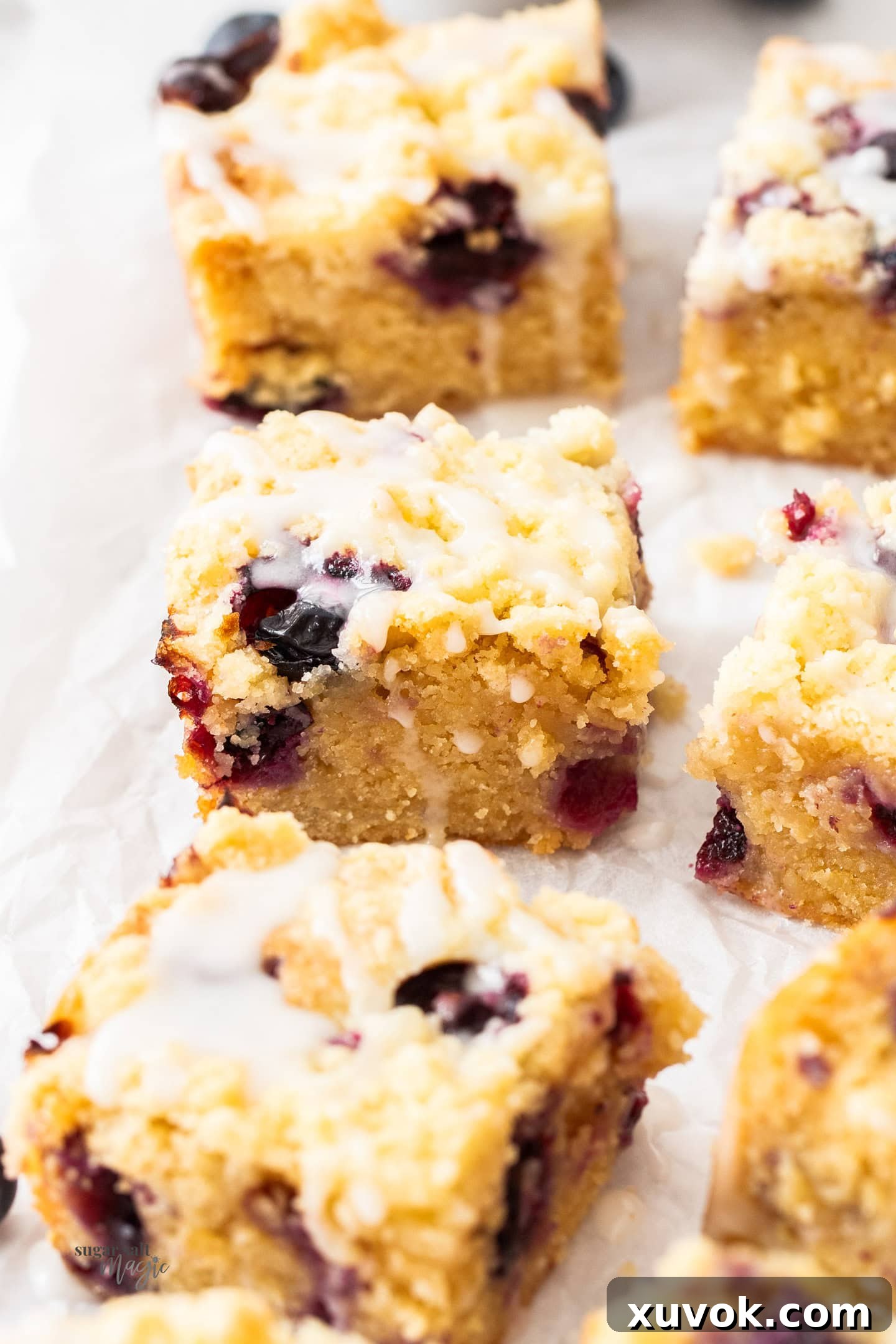 Closeup of 3 blueberry blondies, easy summer dessert bars with blueberries, lined up.