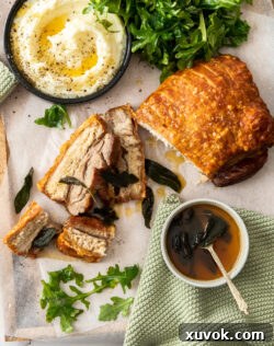 Top down view of a pork belly roast on a wooden tray.