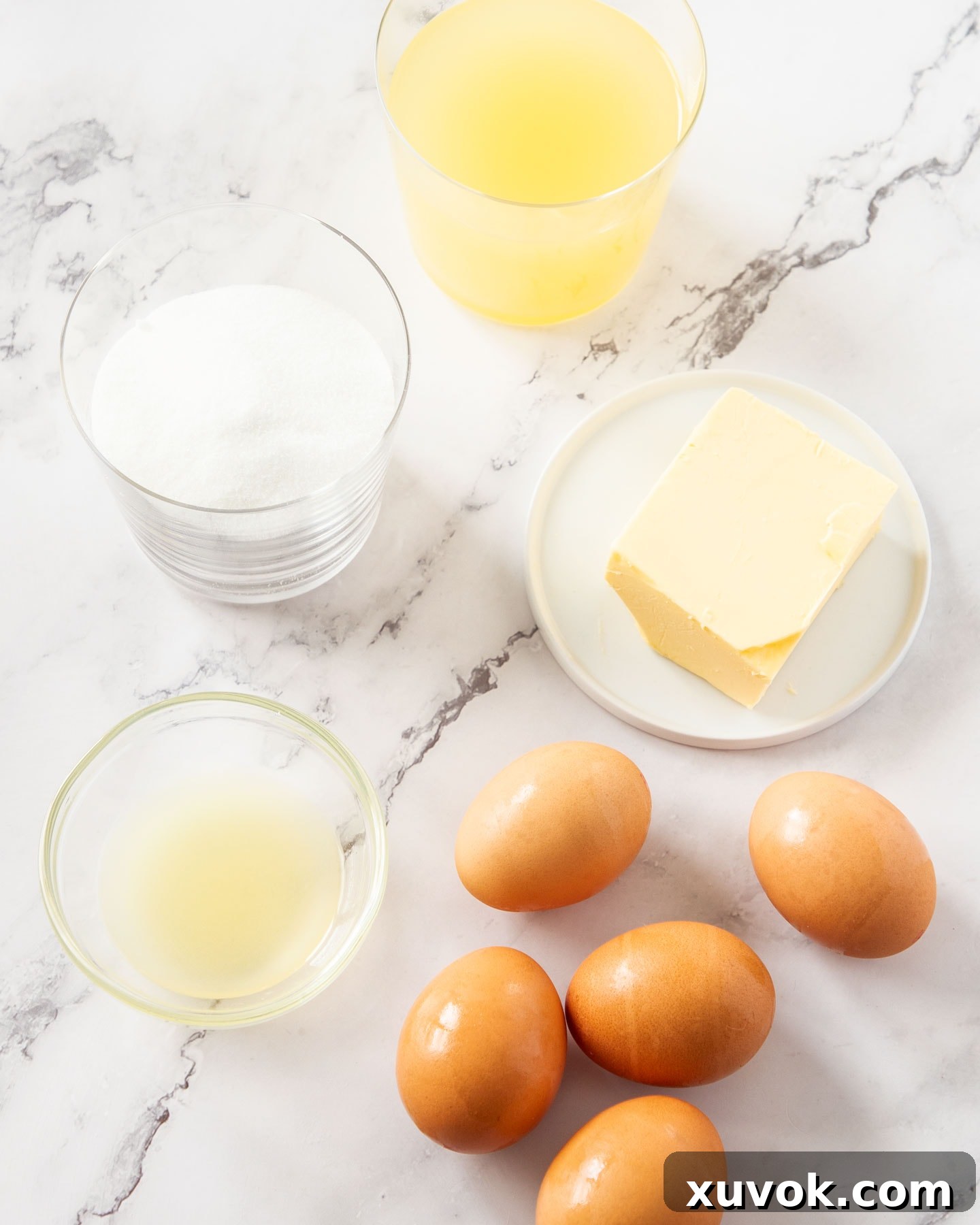 Fresh ingredients for pineapple curd laid out on a marble surface.