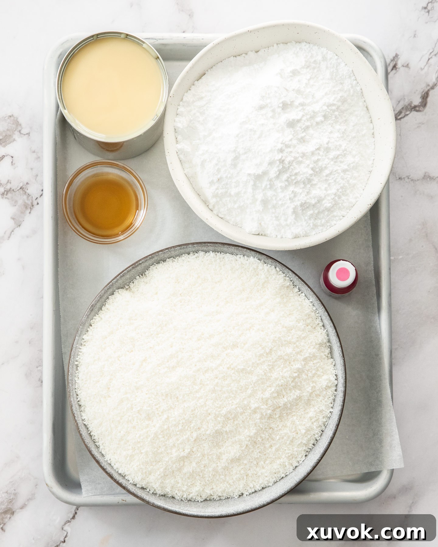 Ingredients for coconut ice laid out on a baking tray, ready for mixing.
