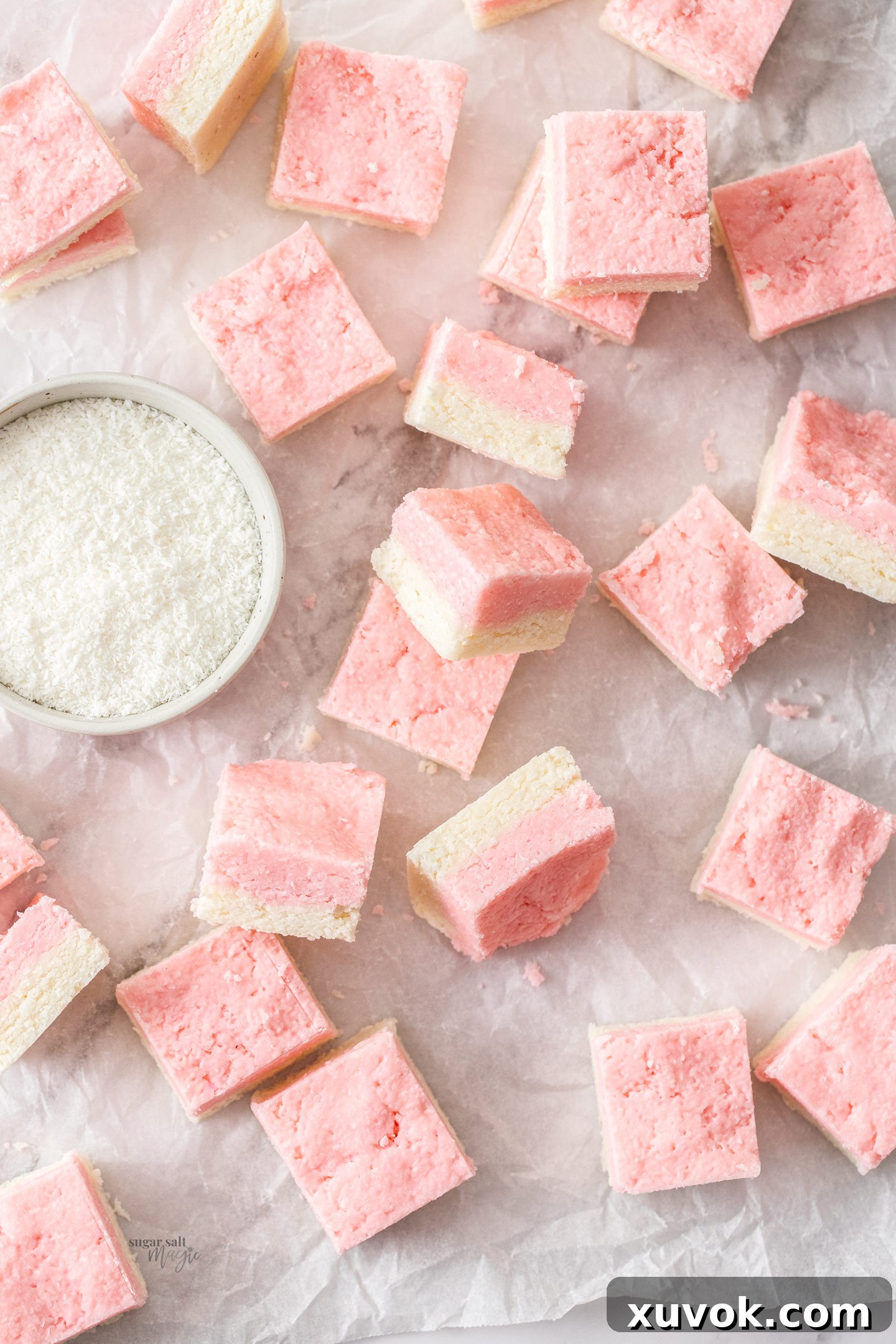 Top down view of a batch of perfectly cut coconut ice squares, showing the neat layers.