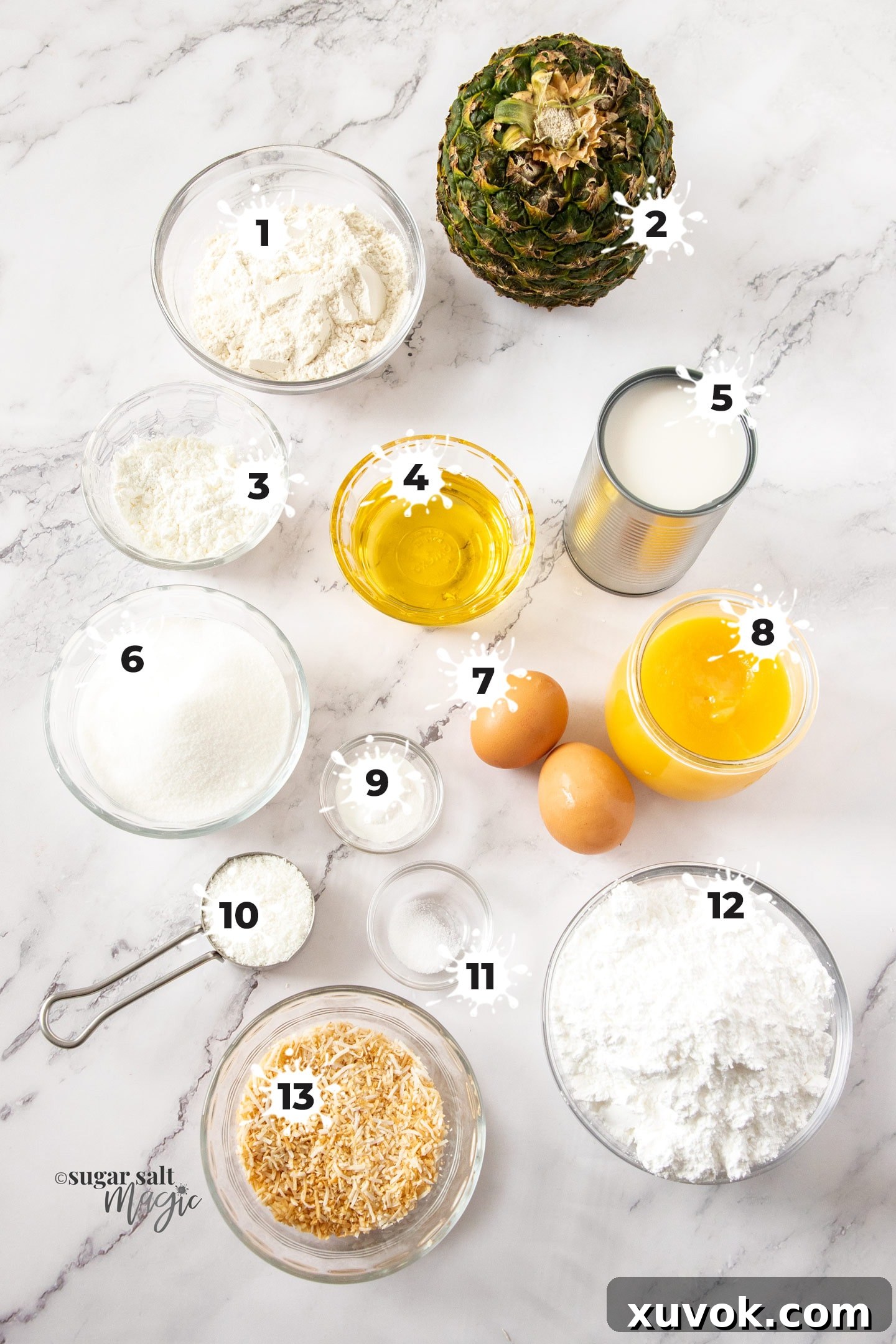 A beautifully arranged flat lay of all the essential ingredients needed to bake irresistible pineapple coconut cupcakes, displayed on a elegant marble surface.