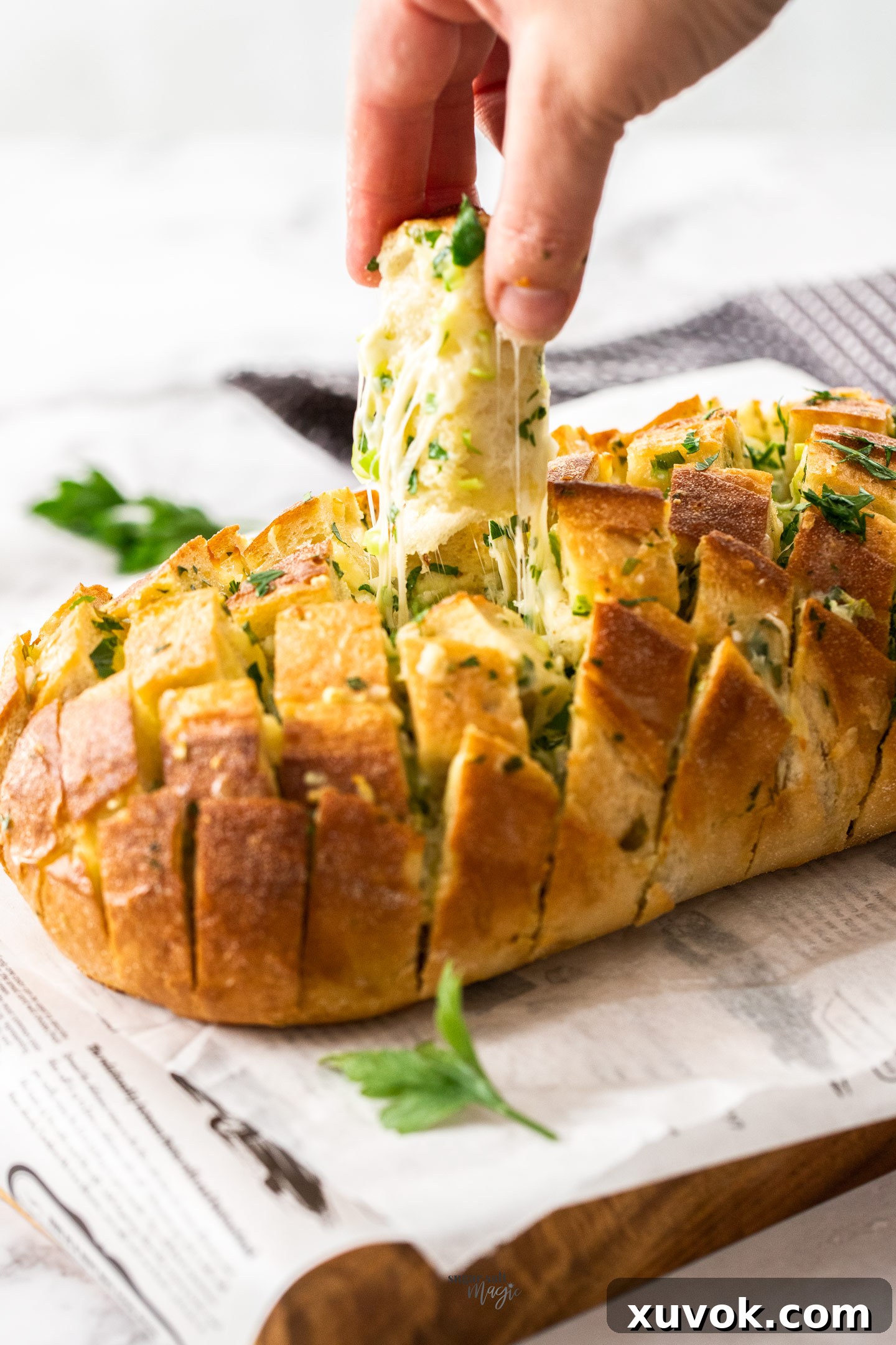 A cube of cheesy bread being pulled from a baked loaf.