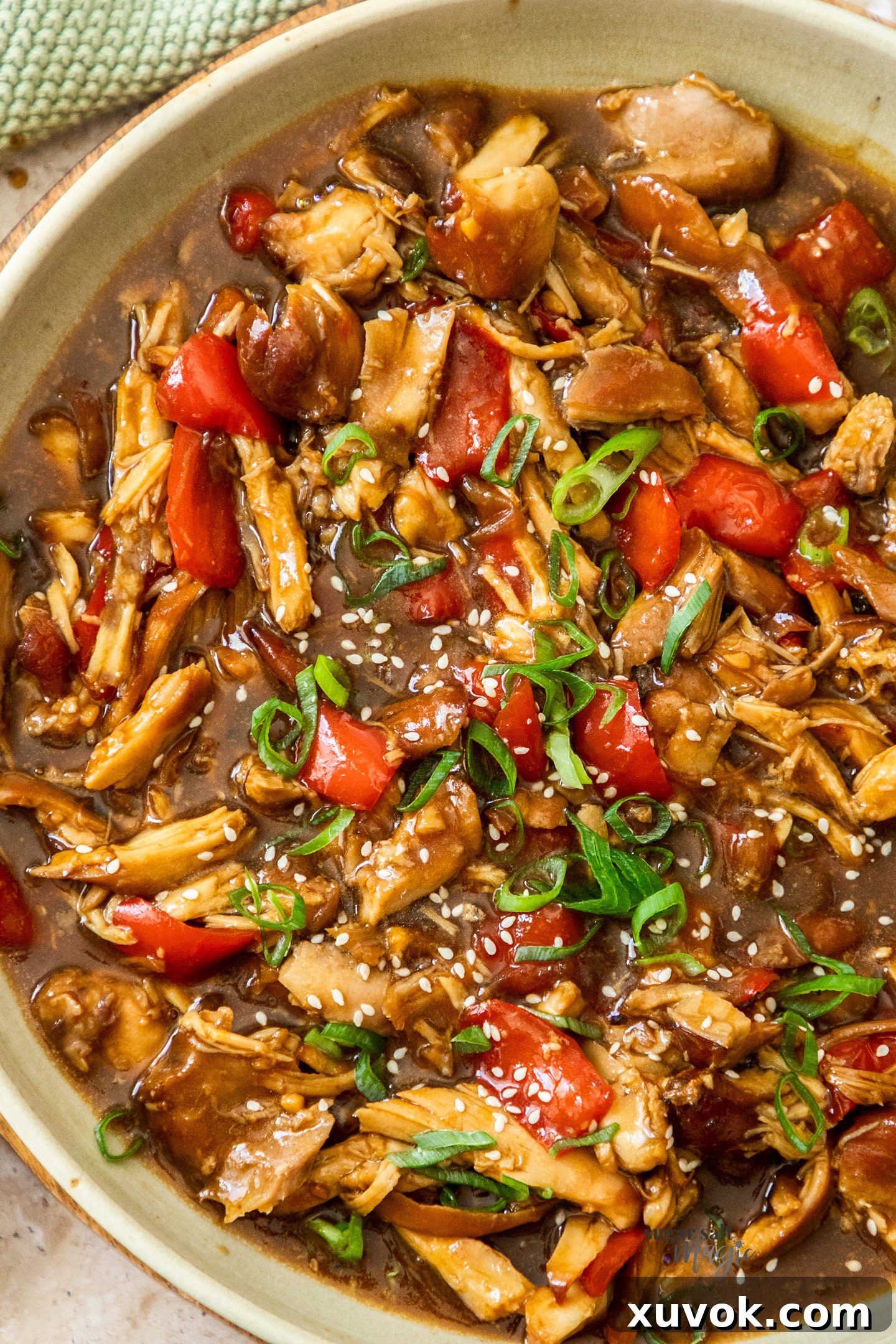Top down view of shredded honey soy chicken in a large serving dish.
