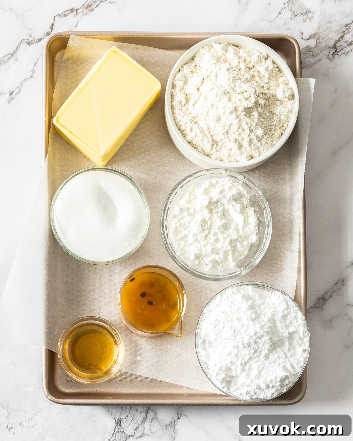 A flat lay photograph showcasing all the simple ingredients required for making shortbread cookies.