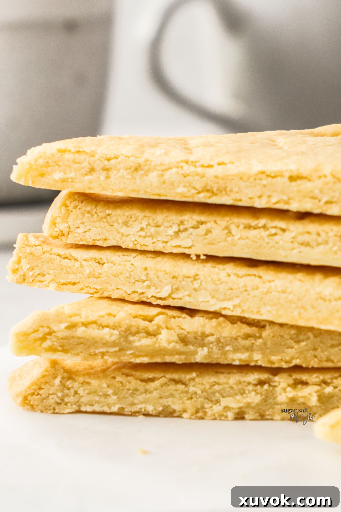 A close-up stack of butter shortbread cookies, showcasing their tender, crumbly texture.