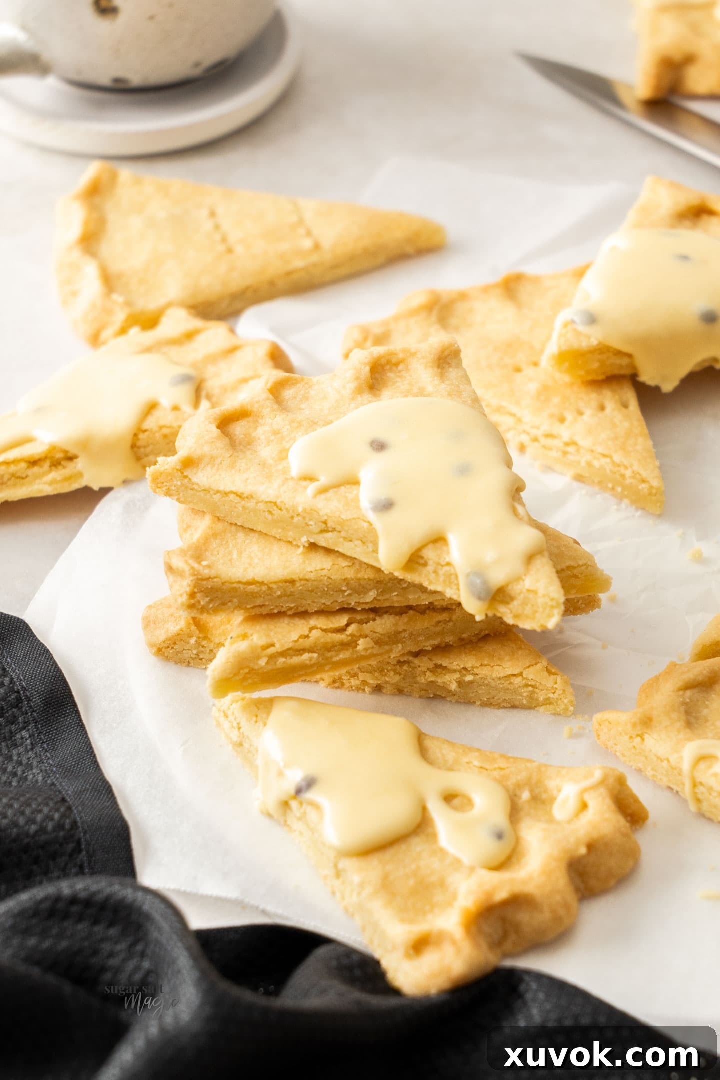 A stack of butter shortbread cookies, with the top cookie elegantly adorned with passionfruit icing.