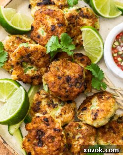 Close up of Thai fish cakes with lime wedges.