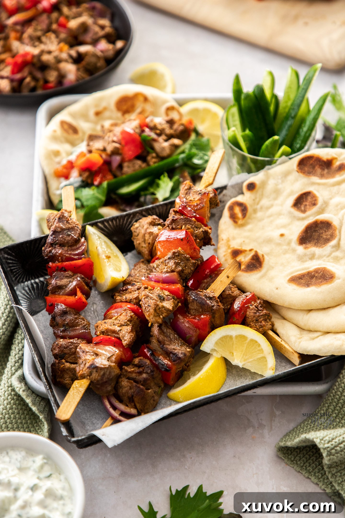 Lamb kebabs on a tray with pita bread, ready to be served.