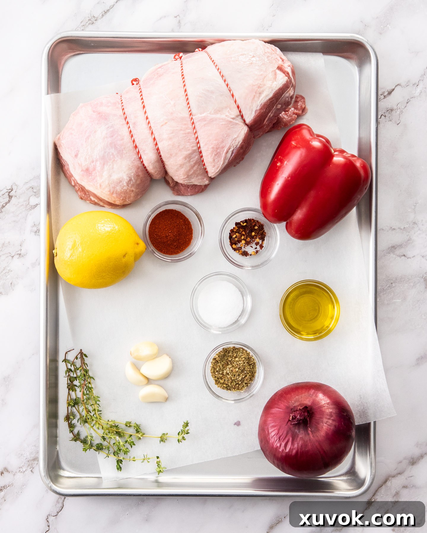Fresh ingredients for Greek lamb kebabs arranged on a baking tray.