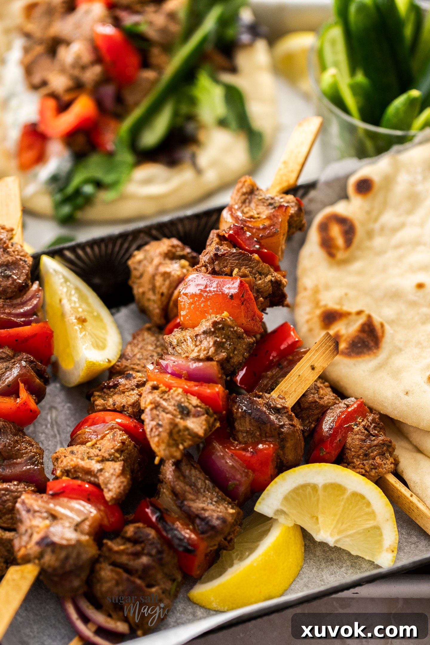 A close-up view of perfectly grilled Greek lamb kebabs on skewers.