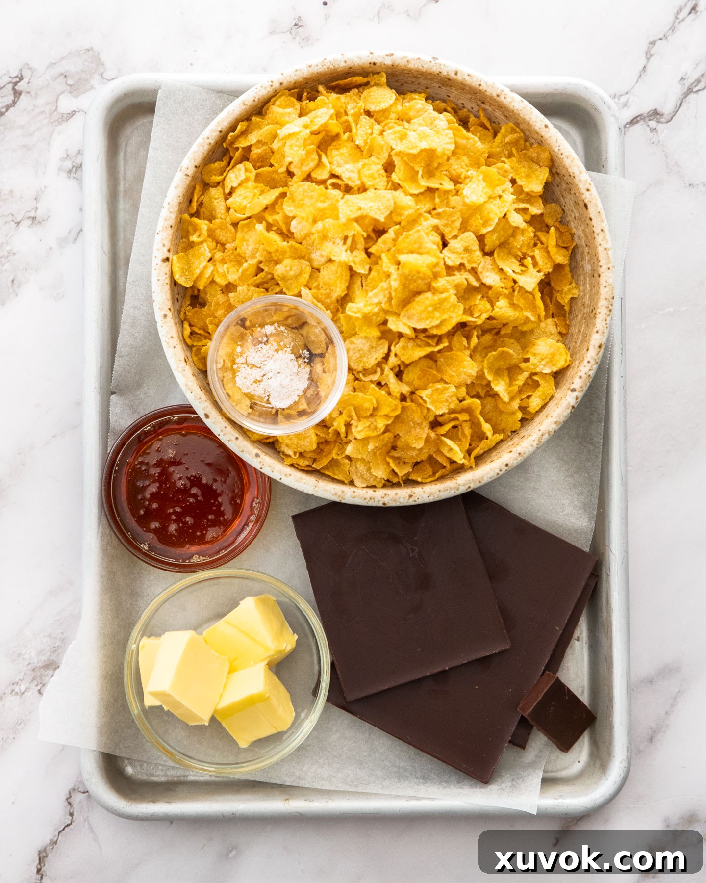 Ingredients for chocolate cornflake cakes on a baking tray.