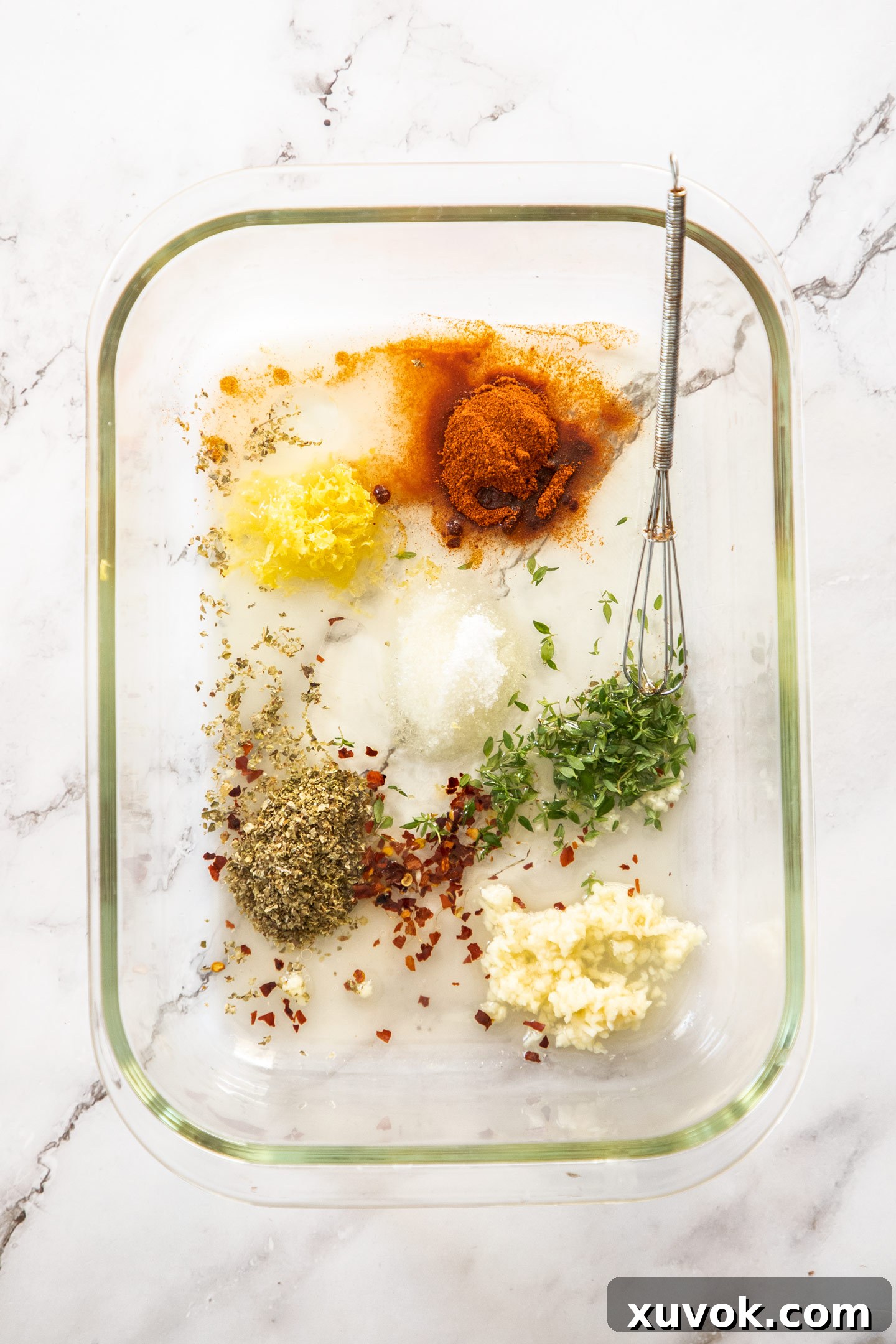 Fresh ingredients for Greek marinade, including whole lemons, garlic cloves, and thyme sprigs, placed together in a large mixing bowl, ready for preparation.