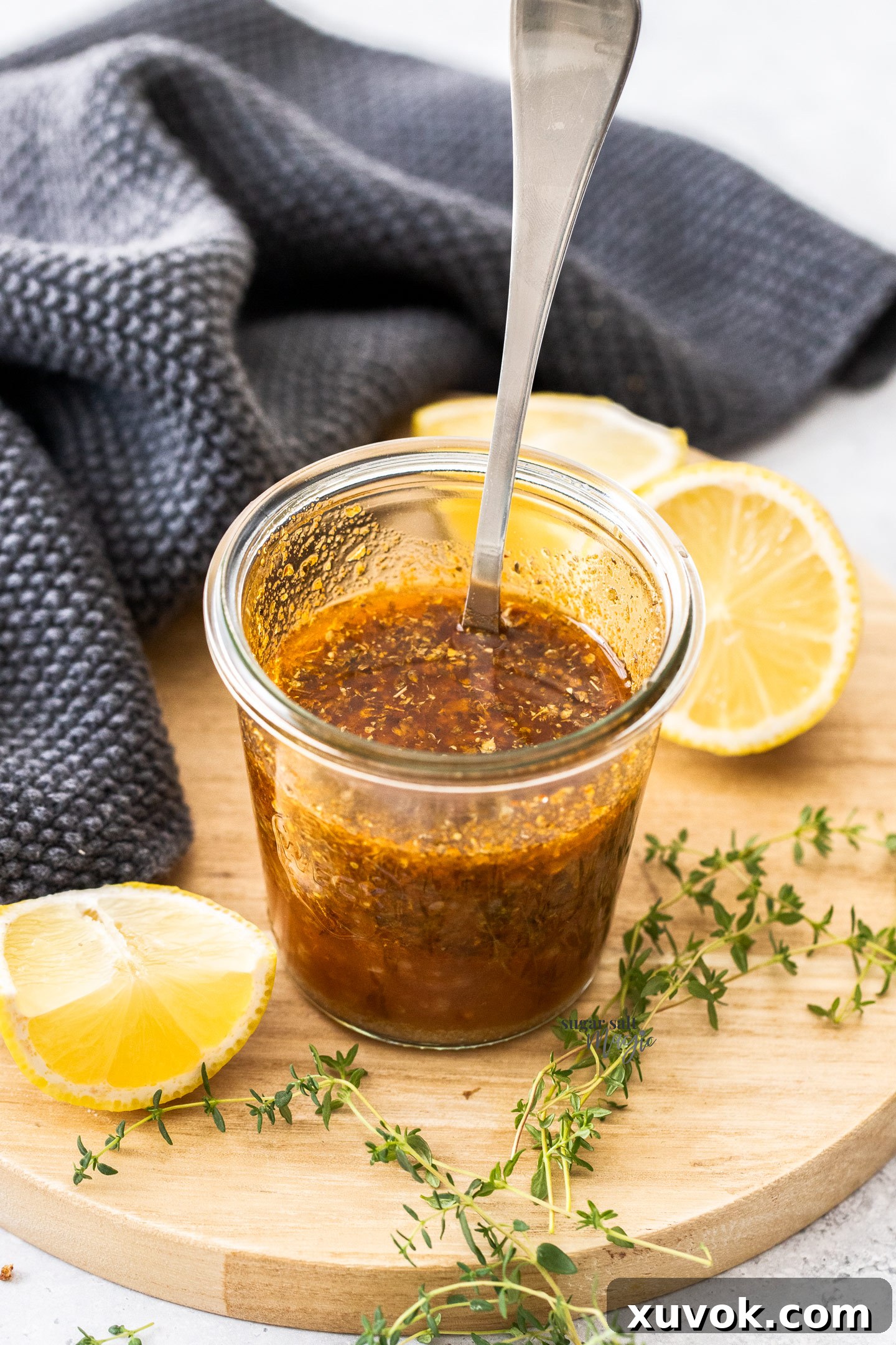 A close-up, top-down view of the thick, textured Greek marinade in a glass jar, highlighting its fresh ingredients and rich color.