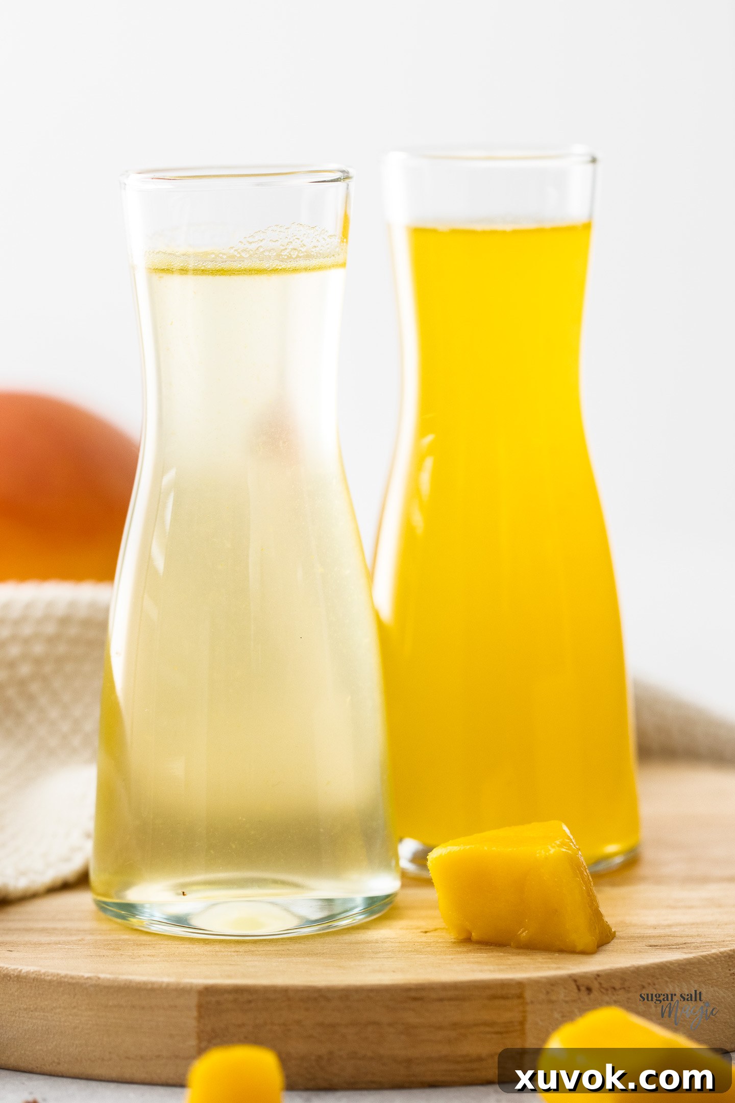 Two mini carafes of vibrant mango syrup, ready to be enjoyed.