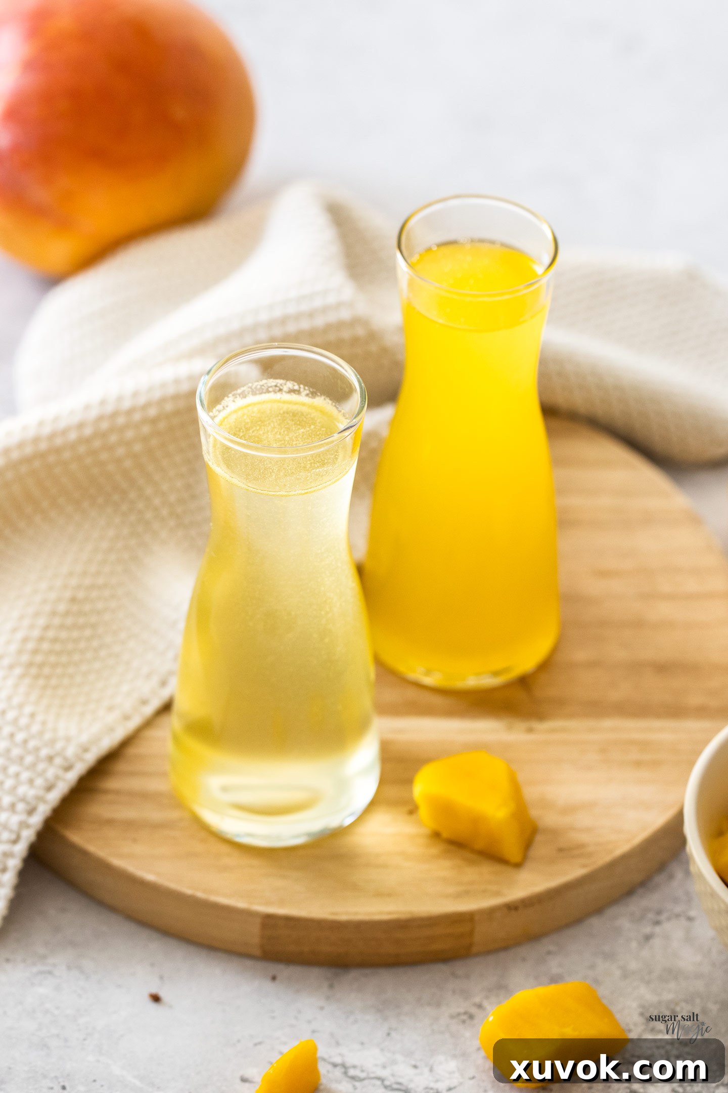 Two elegantly bottled mango syrups displayed on a wooden board, ready for gifting or serving.