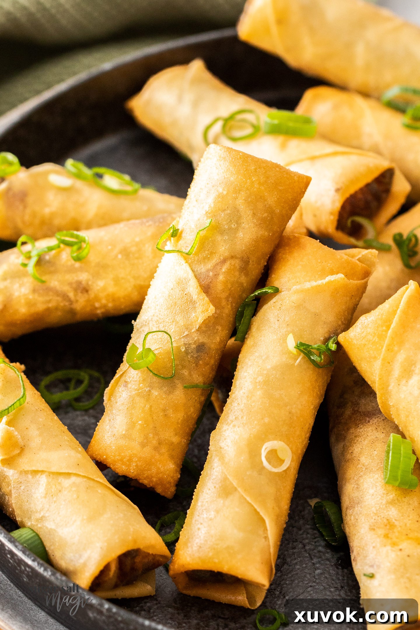 Closeup of crispy golden Chinese spring rolls, freshly fried and ready to be served as an appetizer.