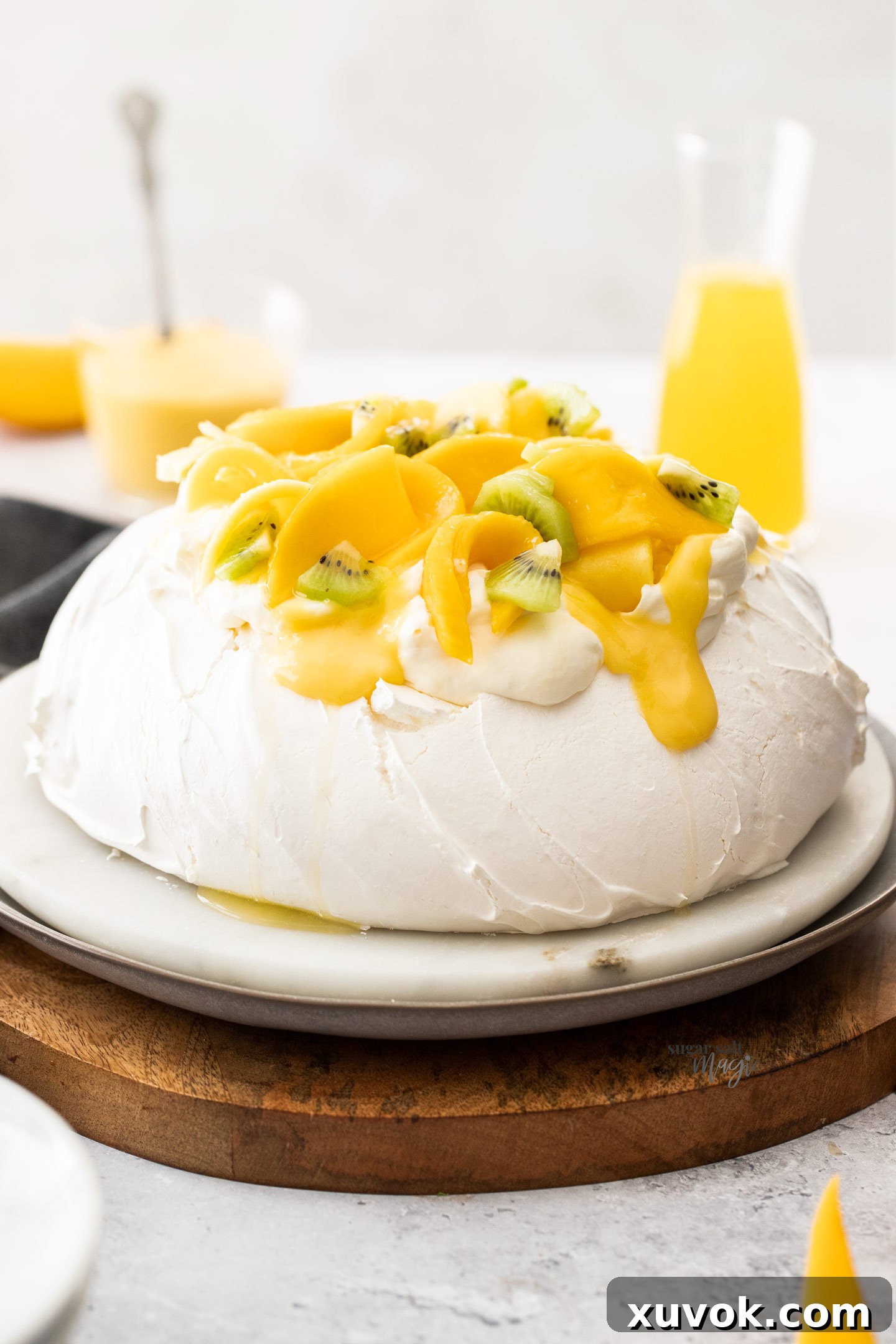 A whole pavlova topped with mango and cream.