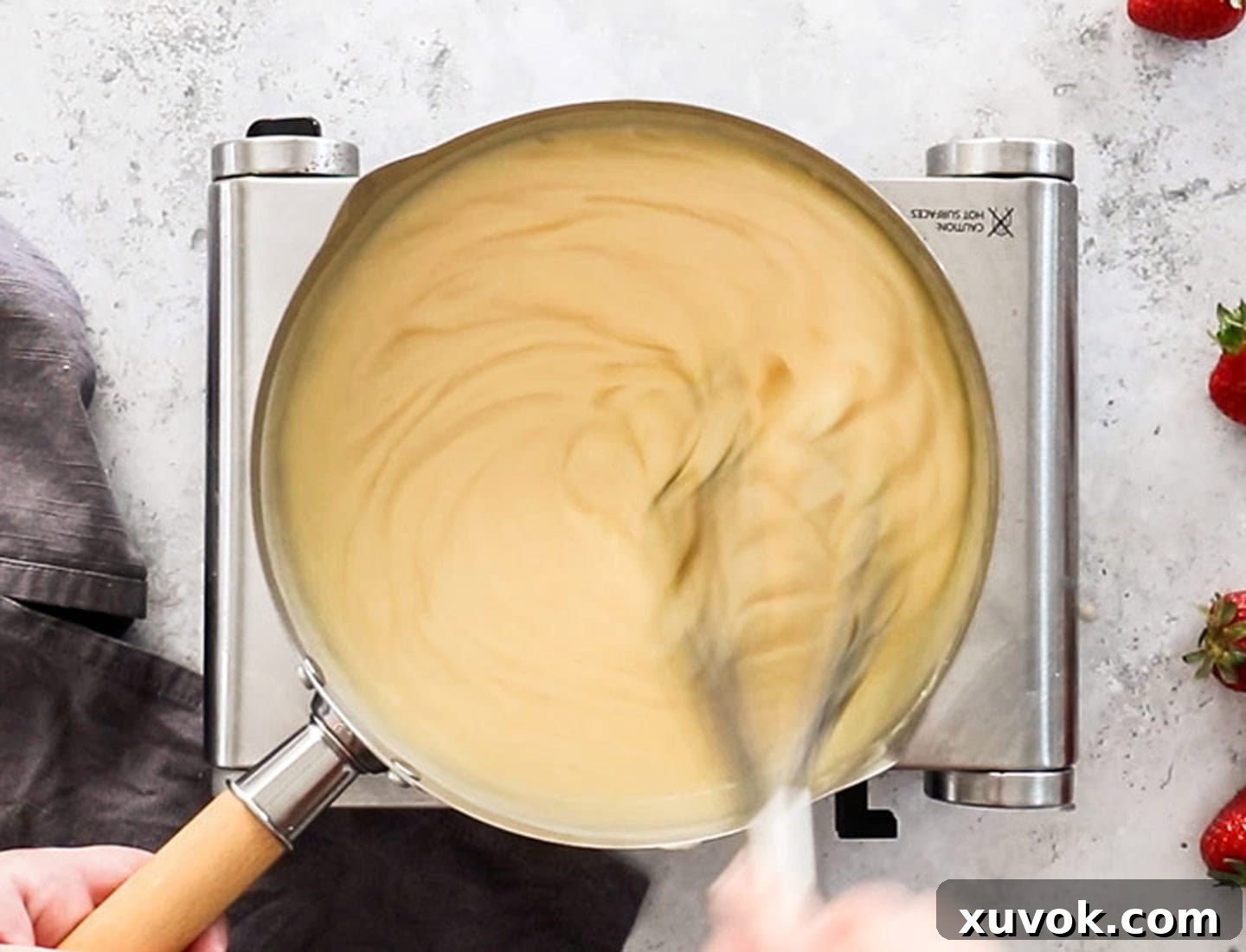 Whisking the custard in a saucepan.