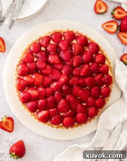 Top down view of a tart topped with fresh strawberries.
