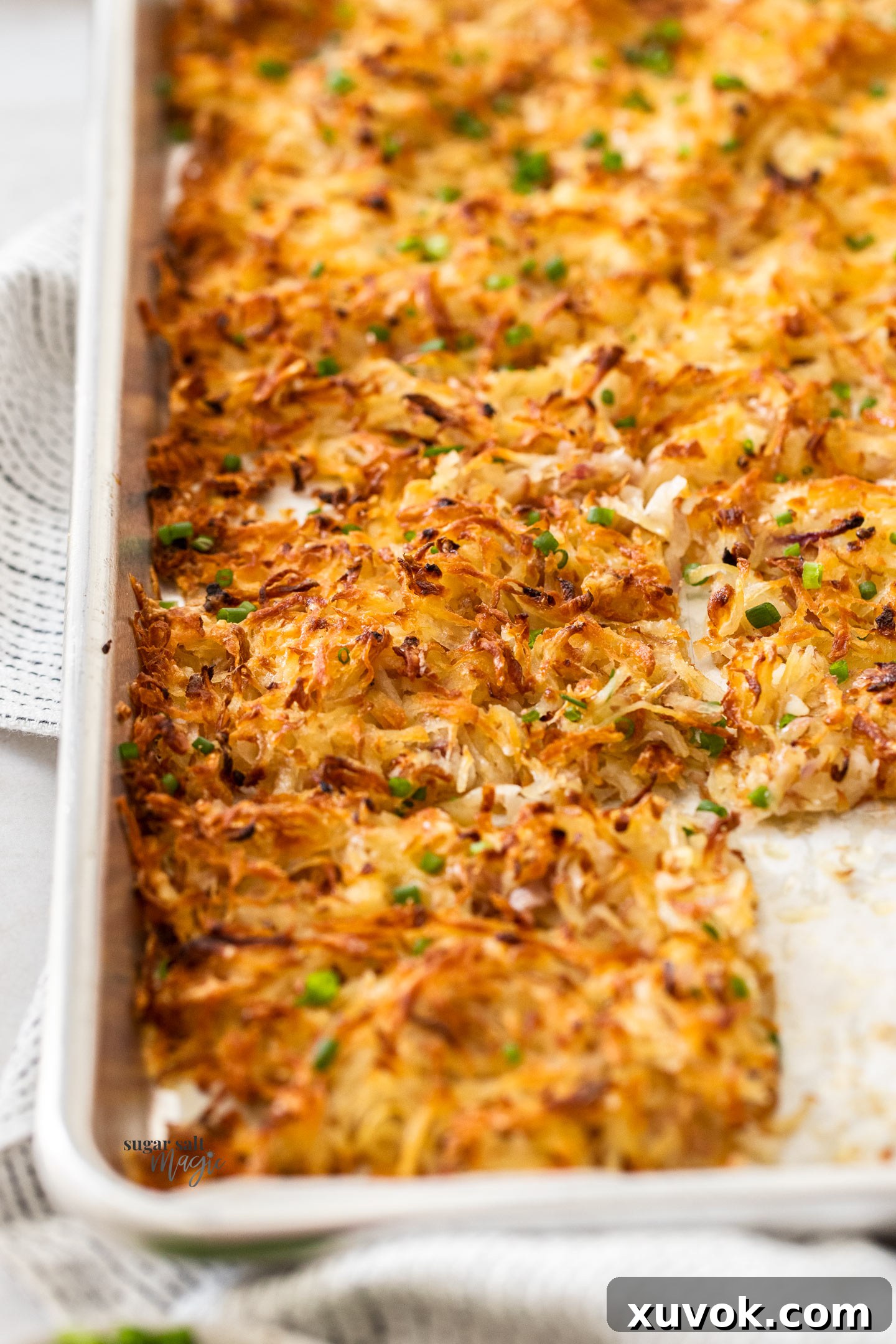 Closeup of baked hash browns in a baking sheet.