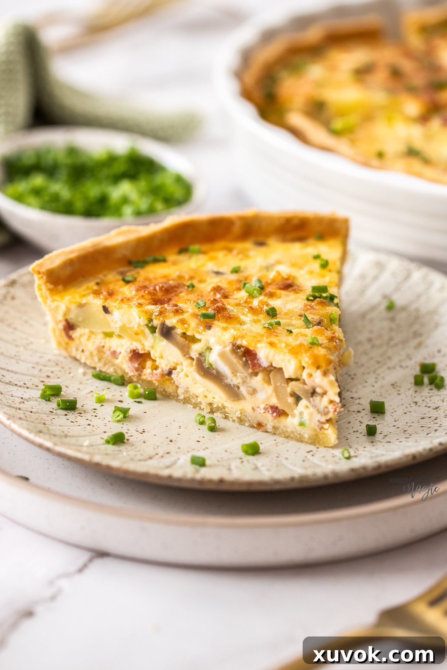 A perfectly baked slice of bacon and potato quiche resting on a small, elegant plate, showcasing its golden, flaky crust and abundant, delicious filling. Ideal for breakfast, brunch, or dinner.