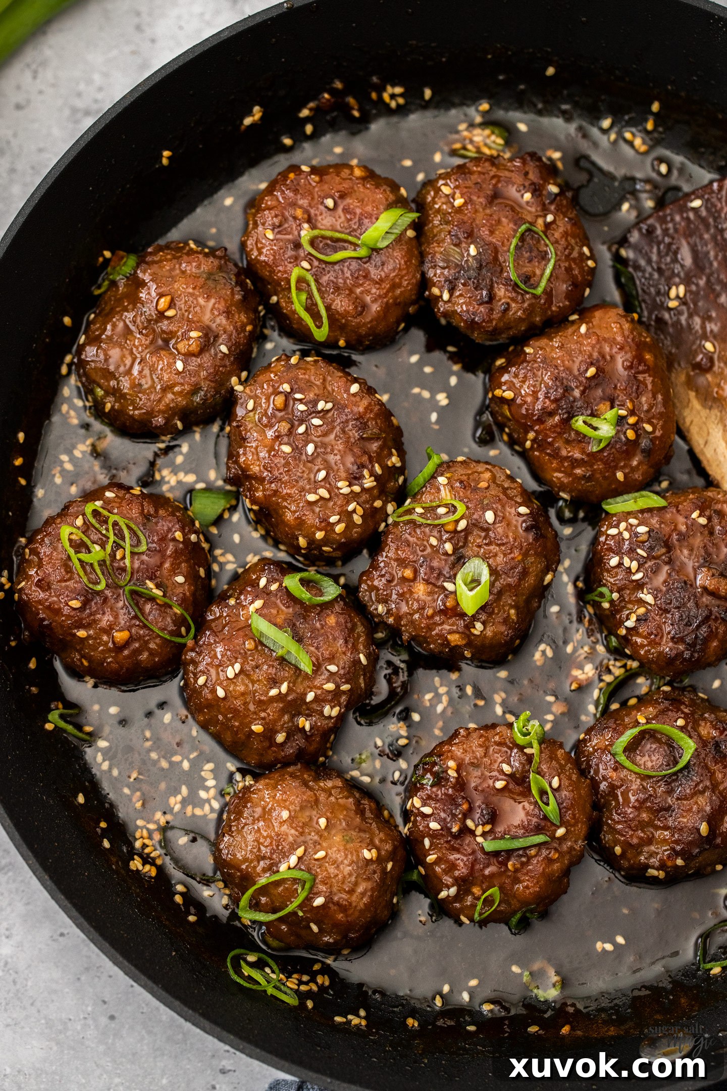 Top down view of rissoles in sauce in a skillet.